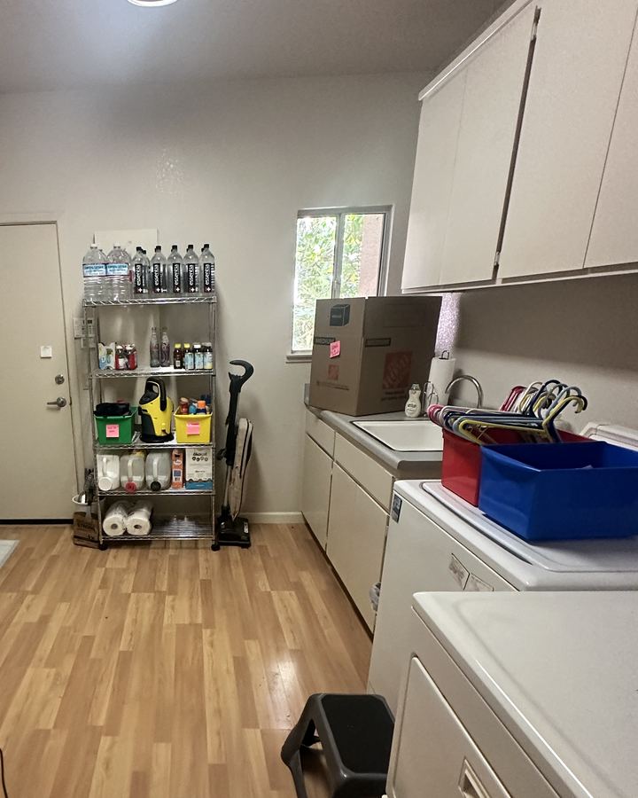 After: the same laundry room with a clear floor and a stocked, labeled shelf