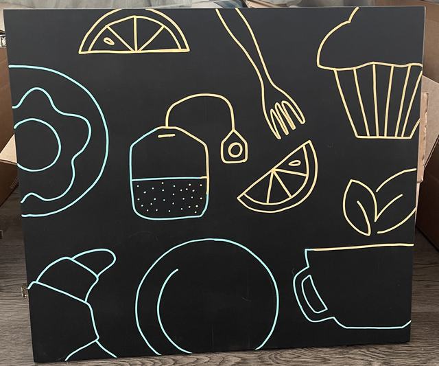 Chalkboard panel with line drawings of pastries, tea and lemons