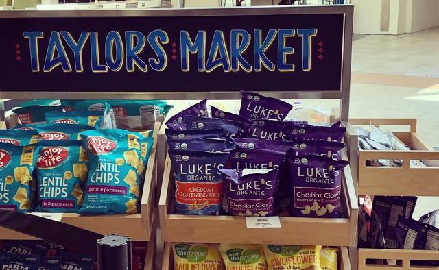 Hand-lettered blue market header above a snack cart